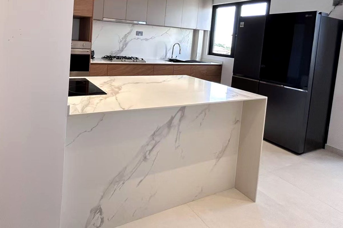 Completed CASAWAVE kitchen with a stone-look waterfall island, wood-grain base cabinets and light grey upper cabinets