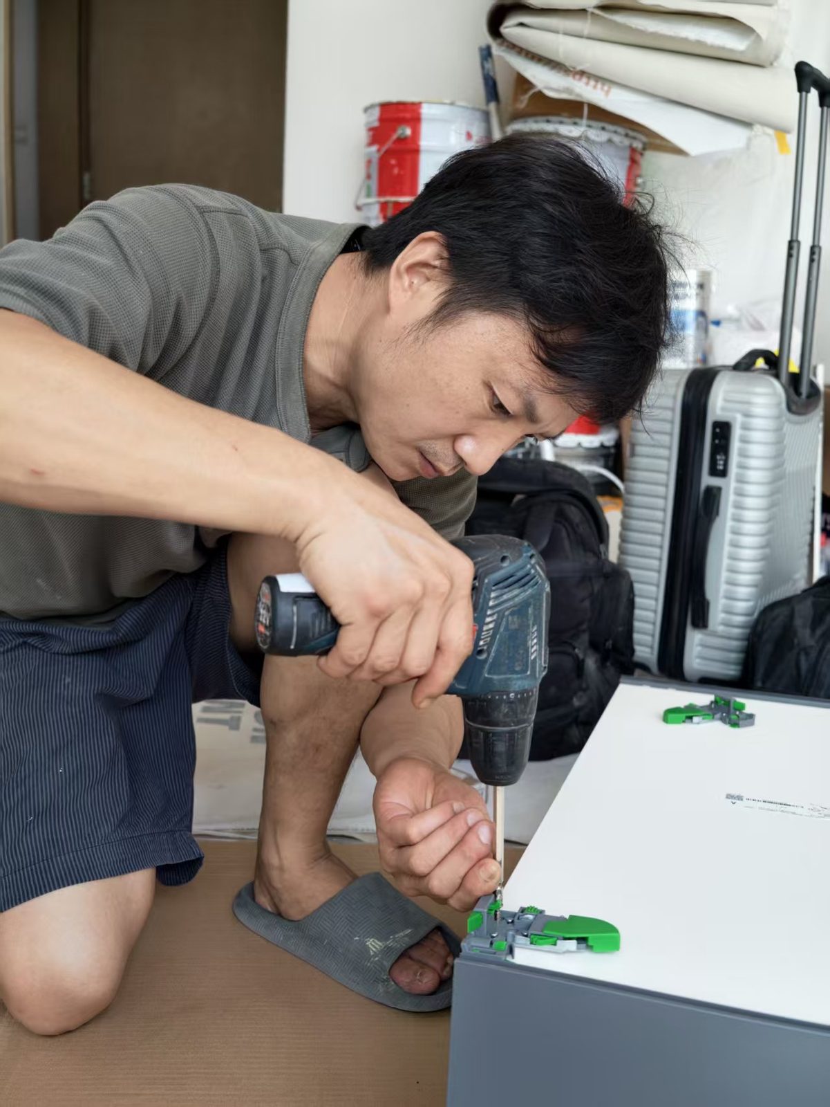 CASAWAVE craftsman assembling custom cabinet carcass with concealed connector hardware during a Singapore renovation