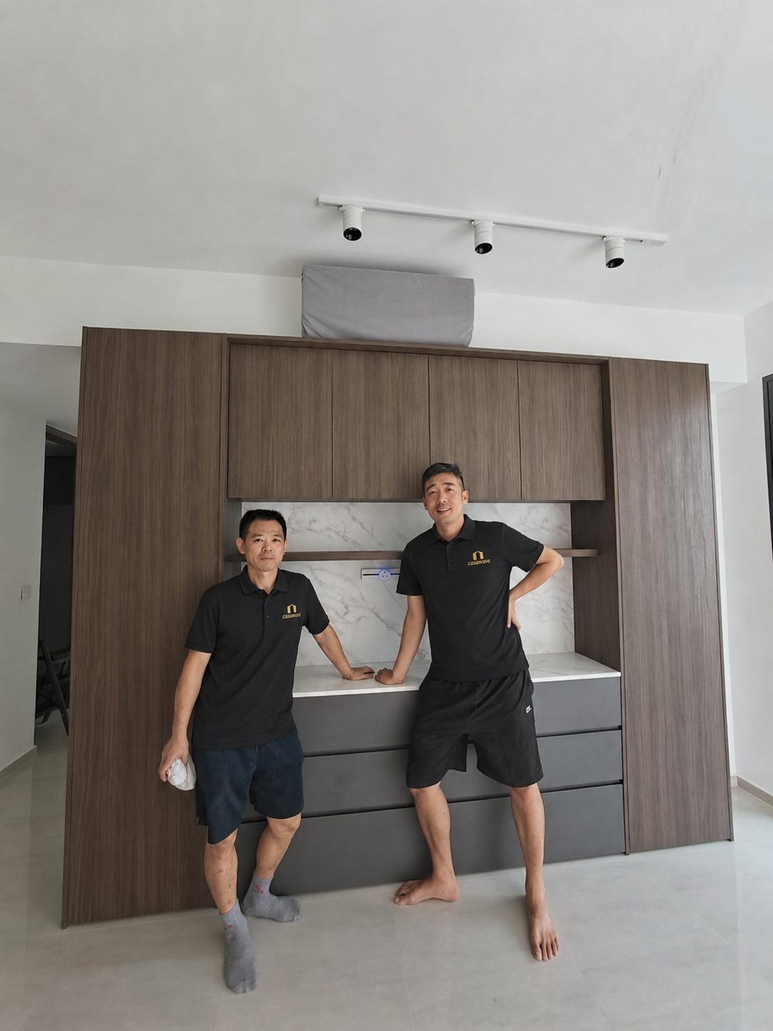 CASAWAVE installation team in branded uniform beside a completed custom feature cabinet in a Singapore home