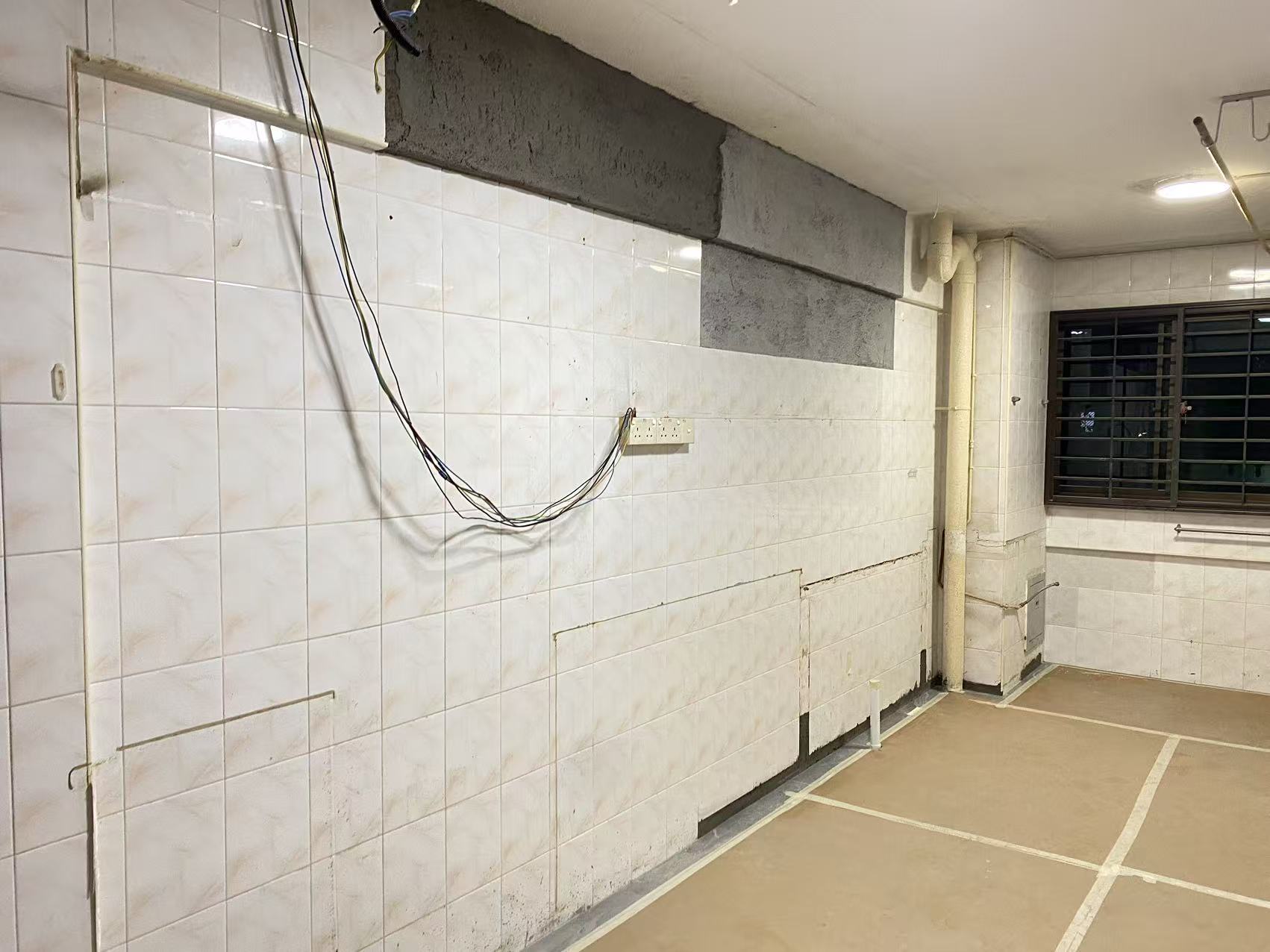 Old HDB kitchen before renovation — exposed wiring, old tiles, no cabinets, Singapore